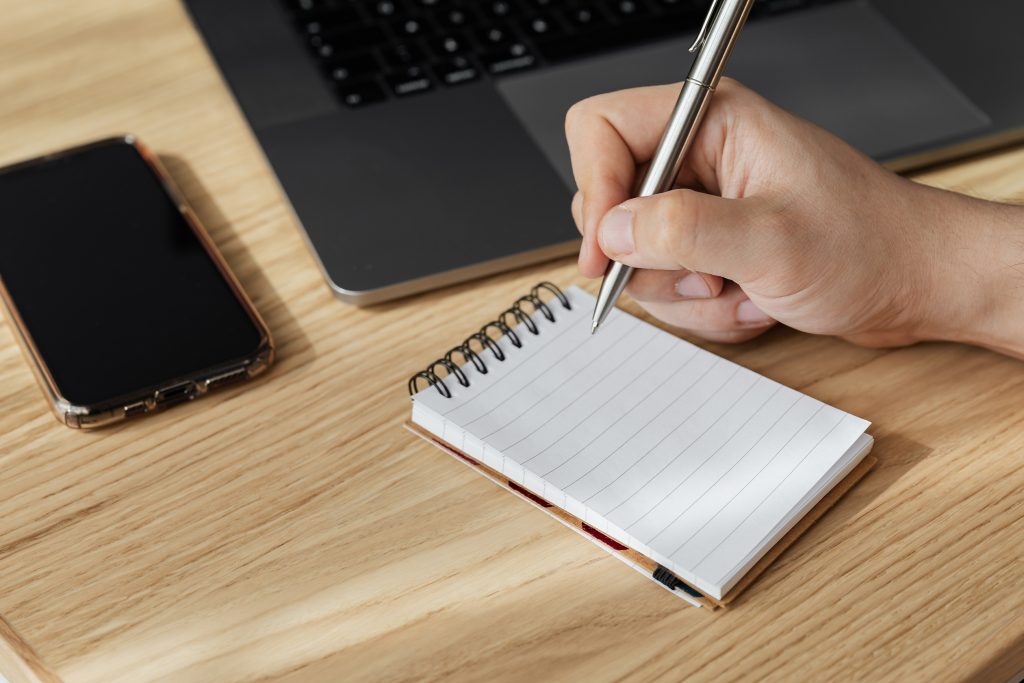 person writing in notebook